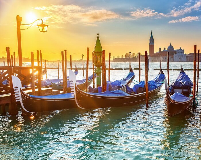 Fotobehang Venetiaanse gondels op de achtergrond van de zon