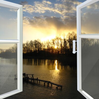 Fotobehang venster geopend aan de rivier met zonsondergang