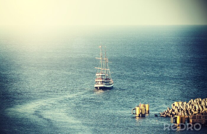 Fotobehang Vintage foto van oude zeilschip de haven te verlaten.