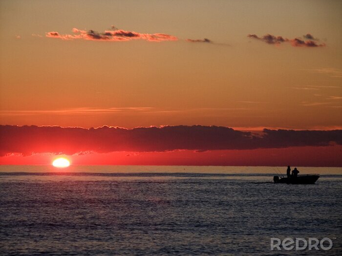 Fotobehang Vissers tegen de achtergrond van de zonsondergang