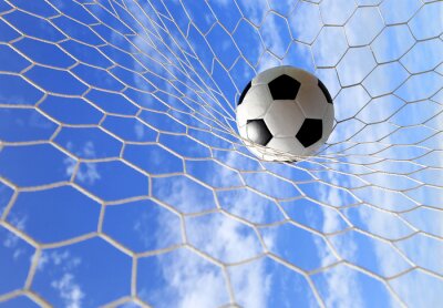 Voetbal in het net met hemelachtergrond