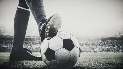 Fotobehang voeten van voetballer betreden voetbalbal voor aftrap in het stadion zwart en wit