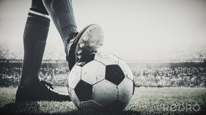 Fotobehang voeten van voetballer betreden voetbalbal voor aftrap in het stadion zwart en wit