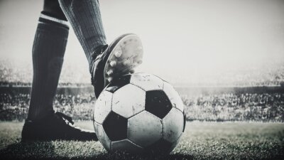 Fotobehang Voeten van voetballer betreden voetbalbal voor aftrap in het stadion zwart en wit