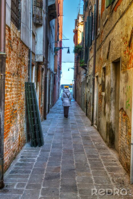 Fotobehang vrouw lopen in een oude backstreet