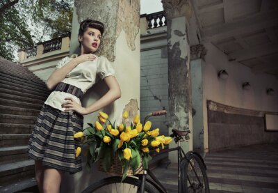 Fotobehang Vrouw met bloemen op een fiets