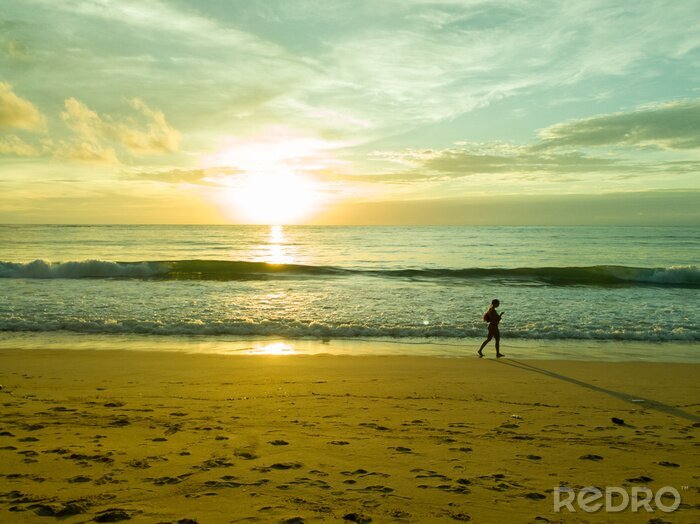 Fotobehang Vrouw op het strand bij zonsondergang
