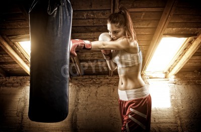 Fotobehang Vrouwelijke bokser bij een bokszak