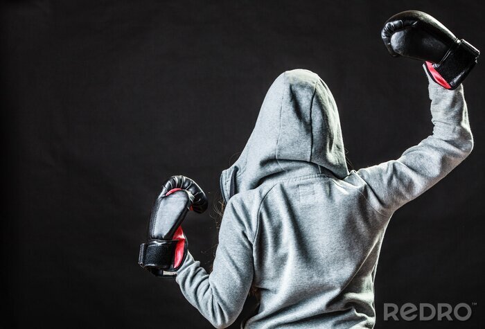 Fotobehang Vrouwelijke bokser met haar rug tegen een zwarte achtergrond