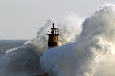 Fotobehang Vuurtoren bedolven door golven