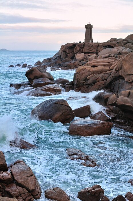 Fotobehang Vuurtoren op een rotsachtig landschap