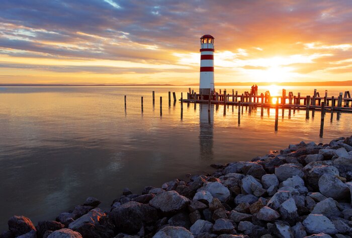 Fotobehang Vuurtoren op een rotsachtig strand