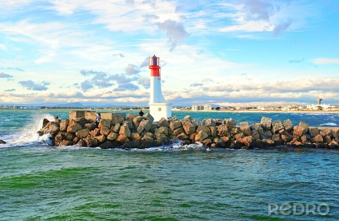 Fotobehang Vuurtoren op een stenen golfbreker