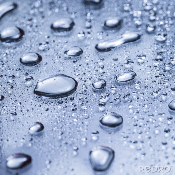 Fotobehang Water druppels op een blauwe oppervlak