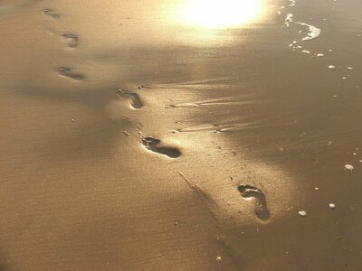 Fotobehang Weerspiegeling van voeten op het strand