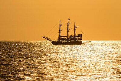 Fotobehang Zeilboot en oranje lucht
