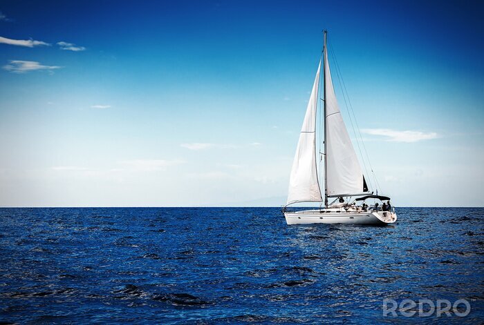 Fotobehang Zeilboot op een azuurblauwe achtergrond