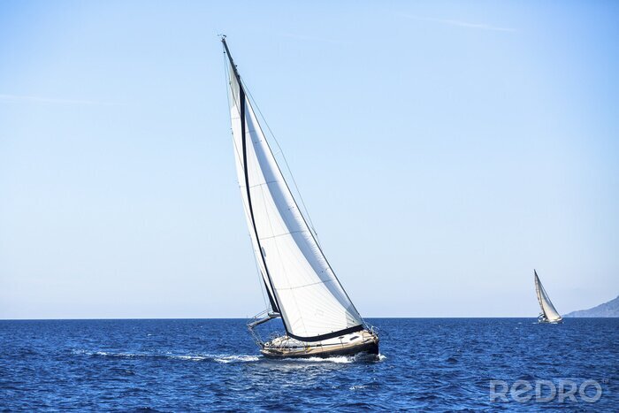 Fotobehang Zeilboot op hemelsblauwe golven