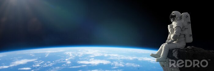 Fotobehang Zittende astronaut met de aarde op de achtergrond
