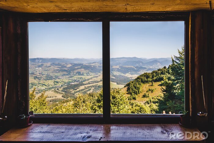 Fotobehang Zomer veld en bergen gezien door het raam