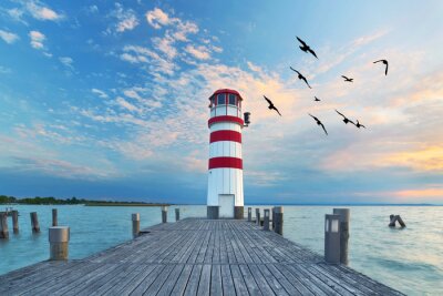 Fotobehang Zonsondergang bij de vuurtoren op het meer