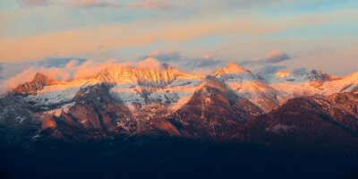 Fotobehang Zonsondergang boven besneeuwde bergtoppen
