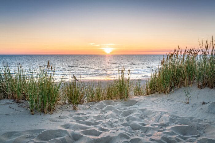 Fotobehang Zonsondergang over de zee en een zandstrand