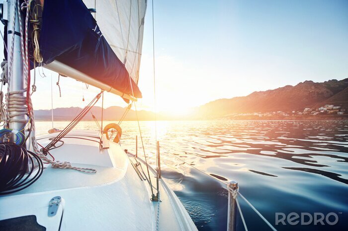 Fotobehang Zonsopgang achter een zeilboot