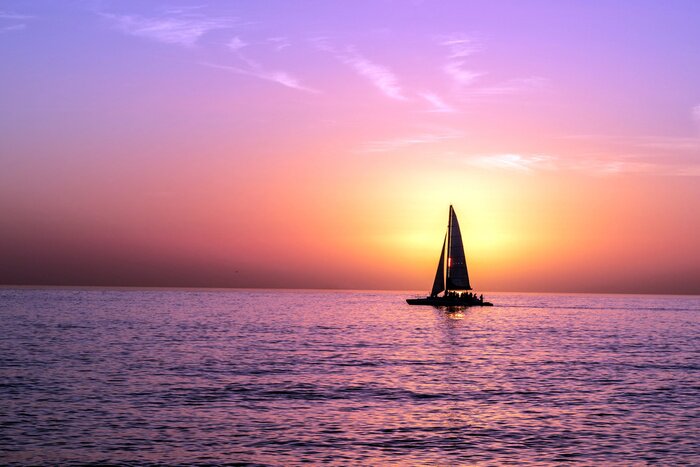 Poster A Sailboat In Front of a Sunset
