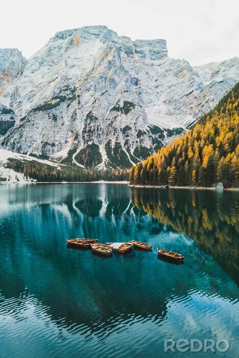 Poster Autumn landscape of Lago di Braies Lake in italian Dolomites mountains in northern Italy. Drone aerial photo with Wooden boats and beautiful reflection in calm water at sunrise. Pragser Wildsee
