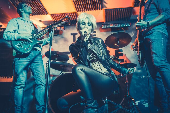 Poster Band playing on stage making music together