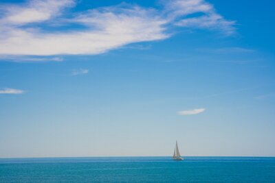 Poster Blue sky seascape with copy space. Calm sea with sailboat on the horizon.
