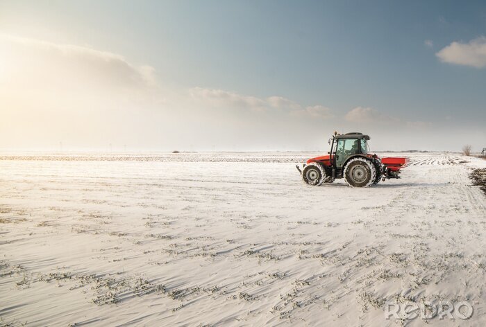Poster Boer met tractor zaaien - zaaien van gewassen op landbouwgronden in de winter
