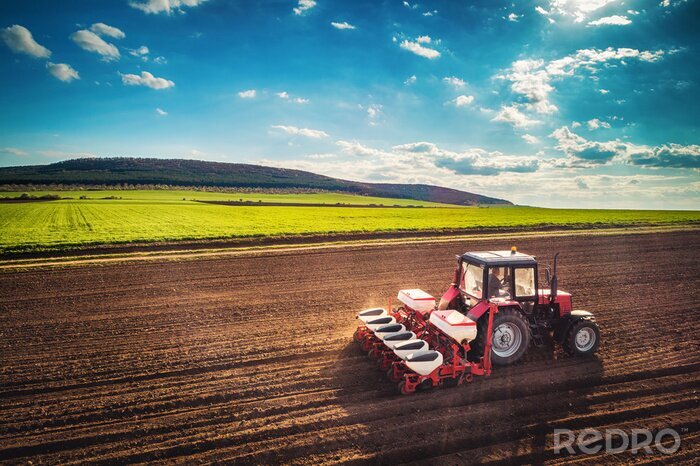 Poster Boer met trekker zaaien gewassen op veld, luchtfoto drone weergave