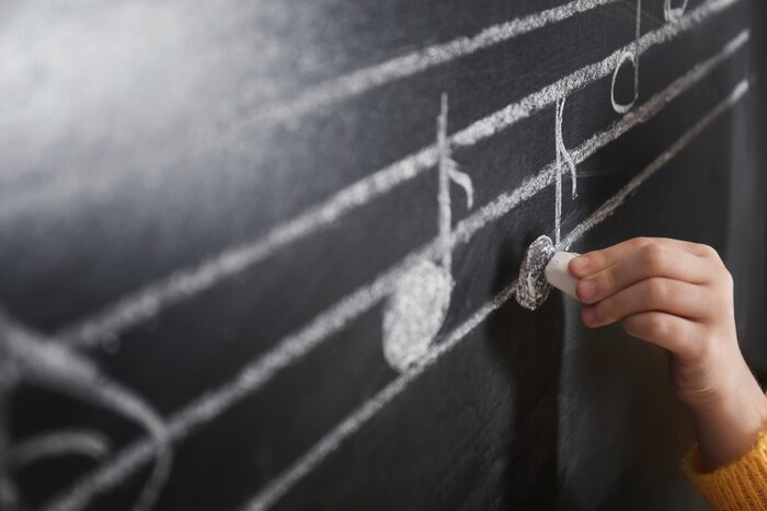 Poster Child writing music notes on blackboard, closeup