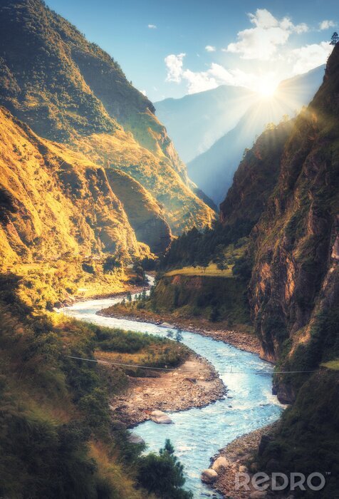 Poster Colorful landscape with high Himalayan mountains, beautiful curving river, green forest, blue sky with clouds and yellow sunlight at sunset in autumn in Nepal. Mountain valley. Travel in Himalayas