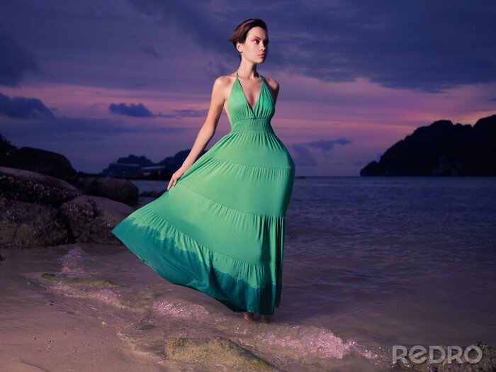 Poster Dame in groene jurk aan kust