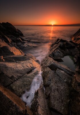 Dawn tussen de rotsen. Overzeese zonsopgang aan de kust van de Zwarte Zee in de buurt Rezovo, Bulgarije