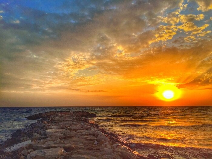 Poster De ondergaande zon boven de zee