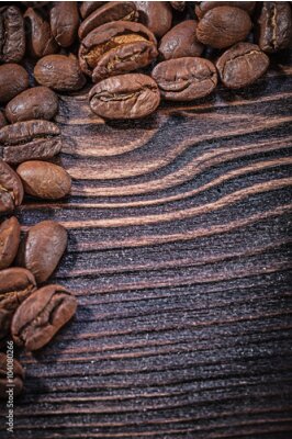 Poster Detail van koffiebonen verspreid over een houten plank.