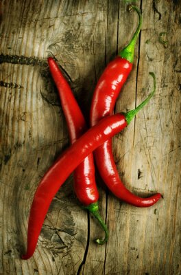 Drie rode paprika's op hout