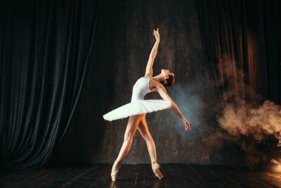 Een ballerina in een witte jurk danst in balletles