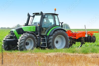 Poster Een groene tractor aan het werk op een veld.