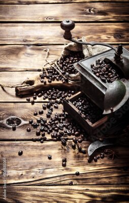 Poster Een klassieke handmolen omringd door verspreide koffiebonen.