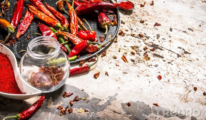 Poster Gedroogde rode chili pepers op een dienblad en in de pot.