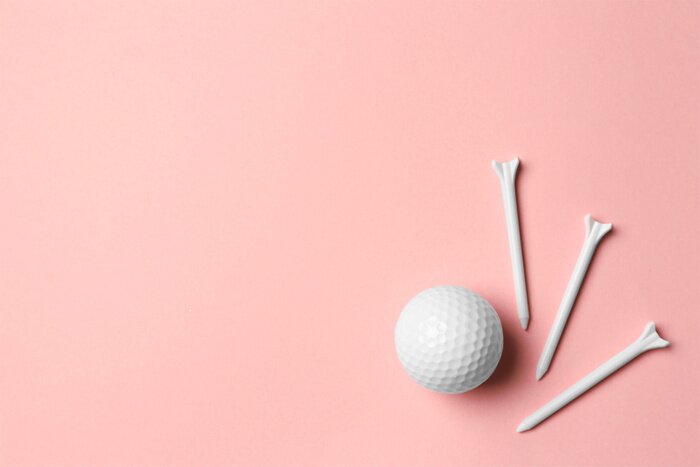 Poster Golf ball and tees on pink background, flat lay. Space for text