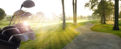 Poster Golfclubs chauffeurs over de prachtige golfbaan in de zonsondergang, zonsopgang tijd.