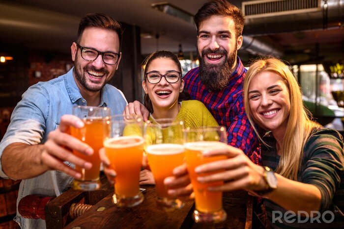 Poster Group of young friends in bar drinking beer toasting