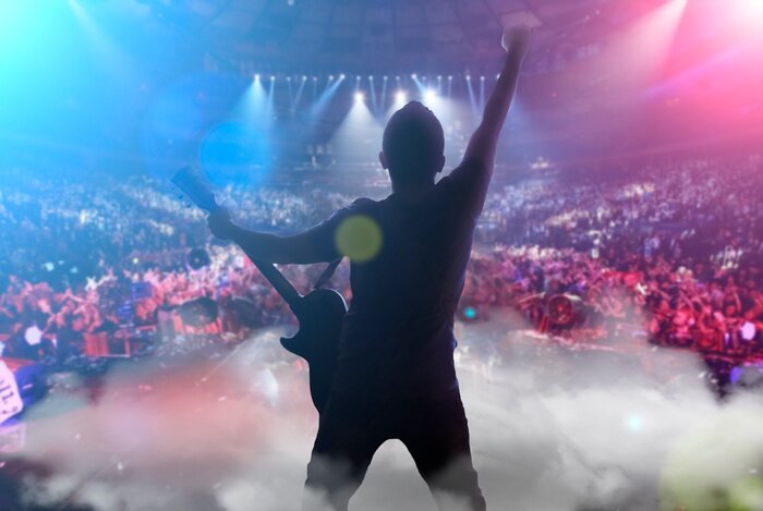 Poster guy on stage with a guitar playing a concert