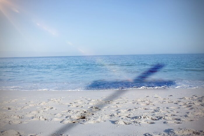 Poster Het lege strand en de schaduw van wegwijzers